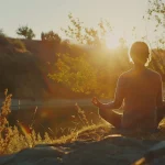 someone meditating outside with the sun shining on them