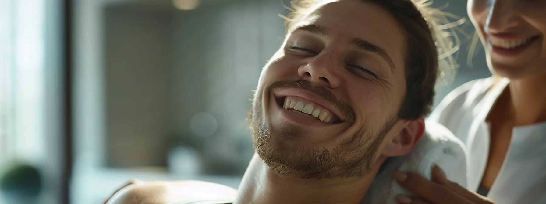 a professional athlete smiling in relief as a dedicated massage therapist applies skilled techniques to enhance recovery and performance.