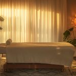 a serene massage therapy room bathed in soft, warm light, featuring a luxurious massage table surrounded by calming essential oils and soothing decor, inviting a sense of relaxation and healing for chronic pain relief.